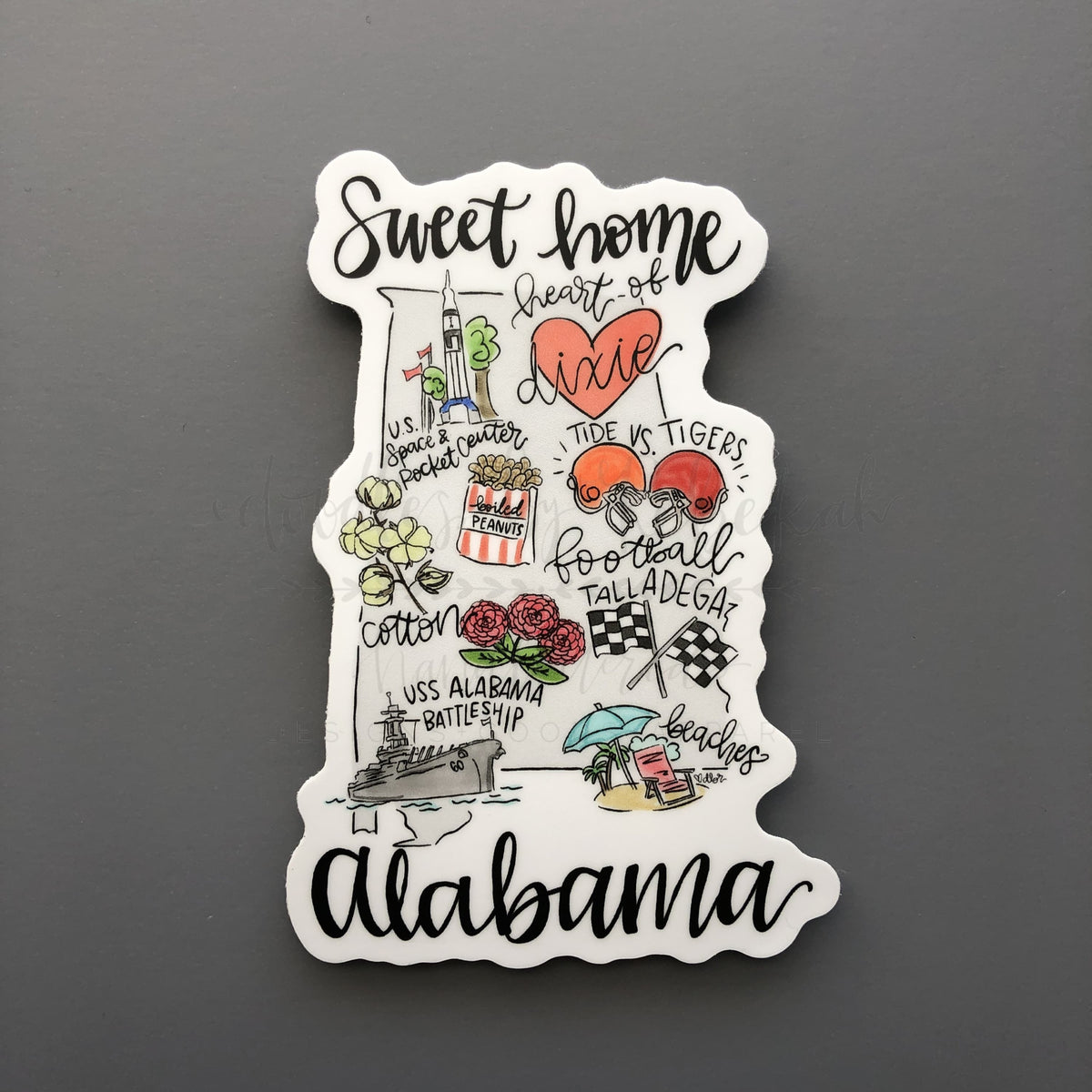 An Alabama map sticker that reads Sweet Home Alabama on a black background