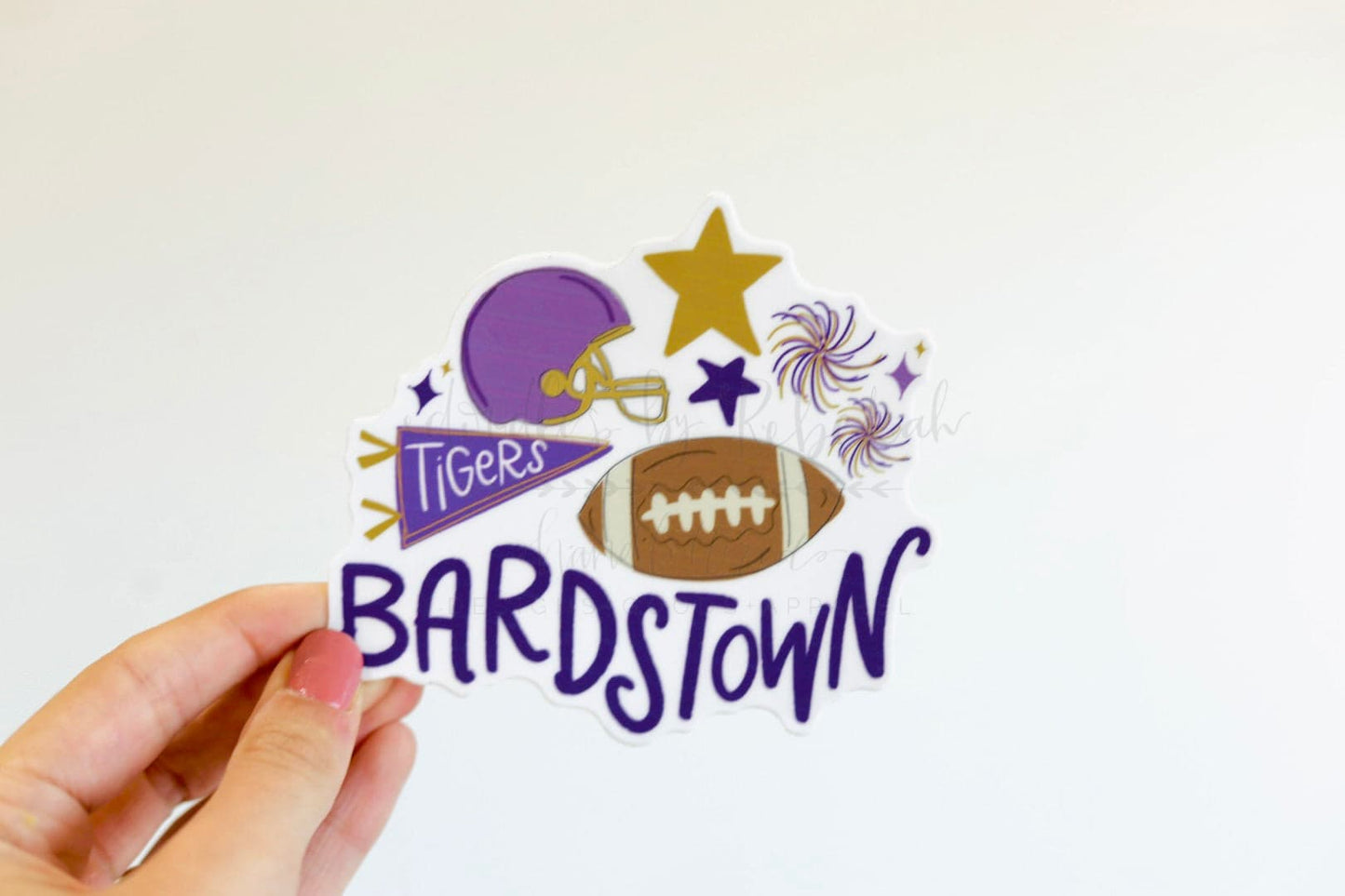 A sticker with a purple and white color scheme featuring text 'BARDSTOWN' and 'TIGERS' along with an image of a football helmet, stars, and a football.