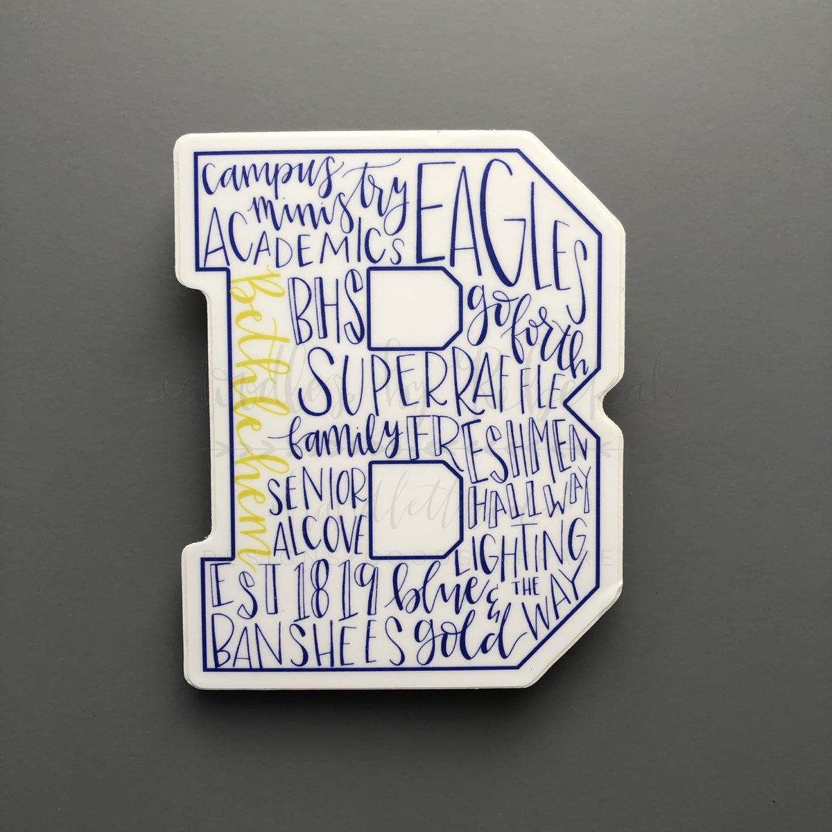 Bethlehem High School typography sticker in a block "B" shape featuring blue and gold school spirit words, perfect for student laptops or water bottles.