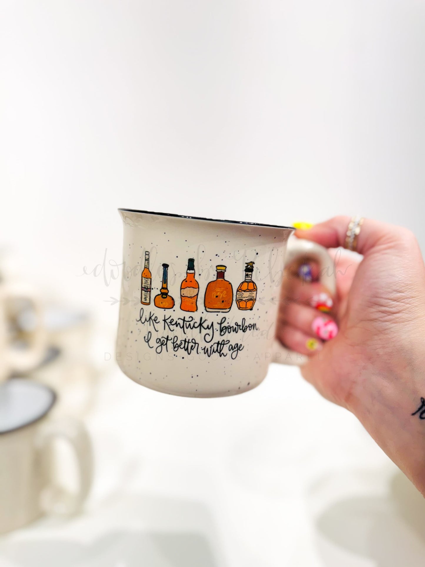 Kentucky bourbon campfire mug with whimsical bottle graphics and "better with age" calligraphy, an ideal gift for bourbon lovers and birthdays.