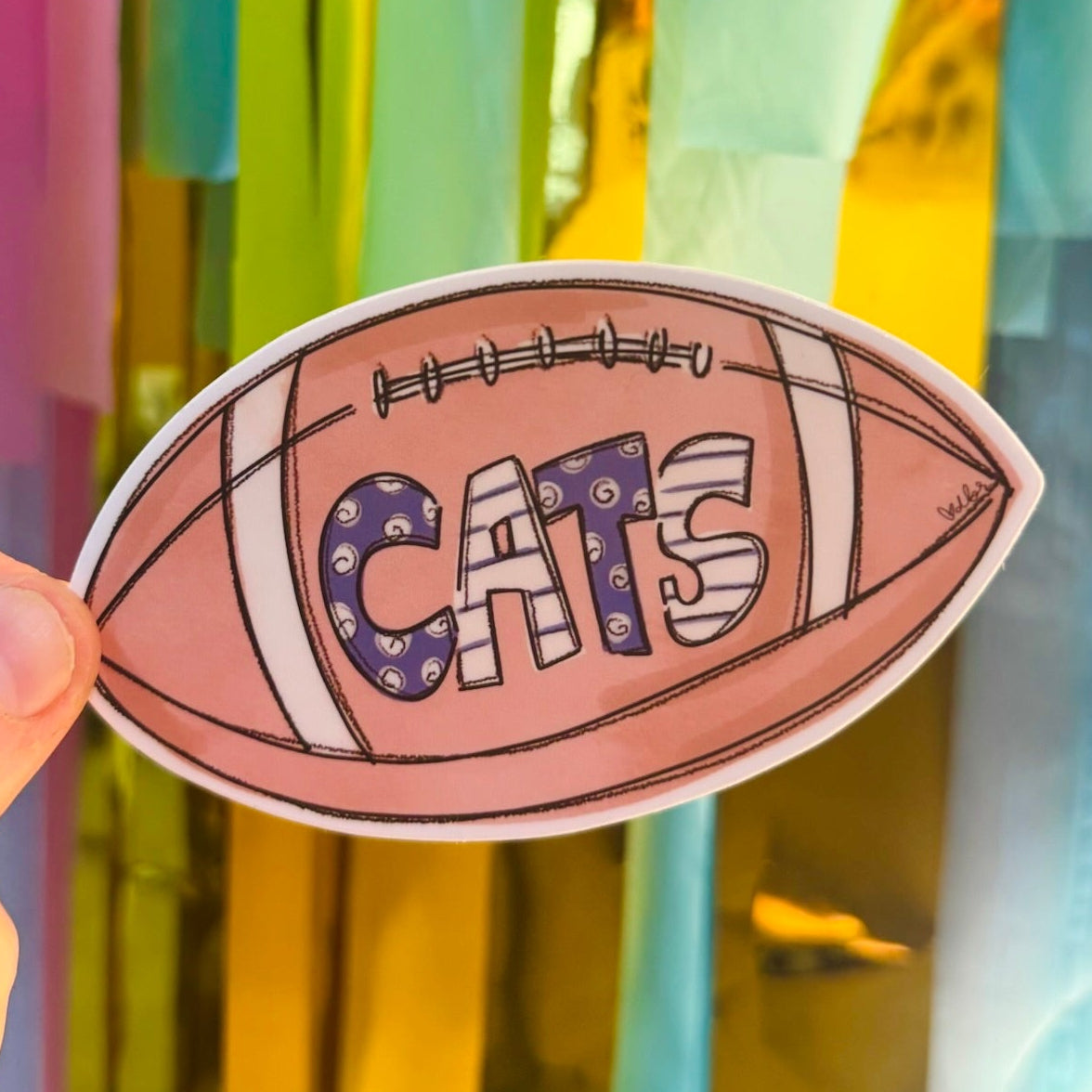 Doodles by Rebekah "CATS" football spirit sticker. This hand-painted sports decal in purple and white is a perfect gift for fans and students to show their team pride on water bottles, laptops, and game-day gear.