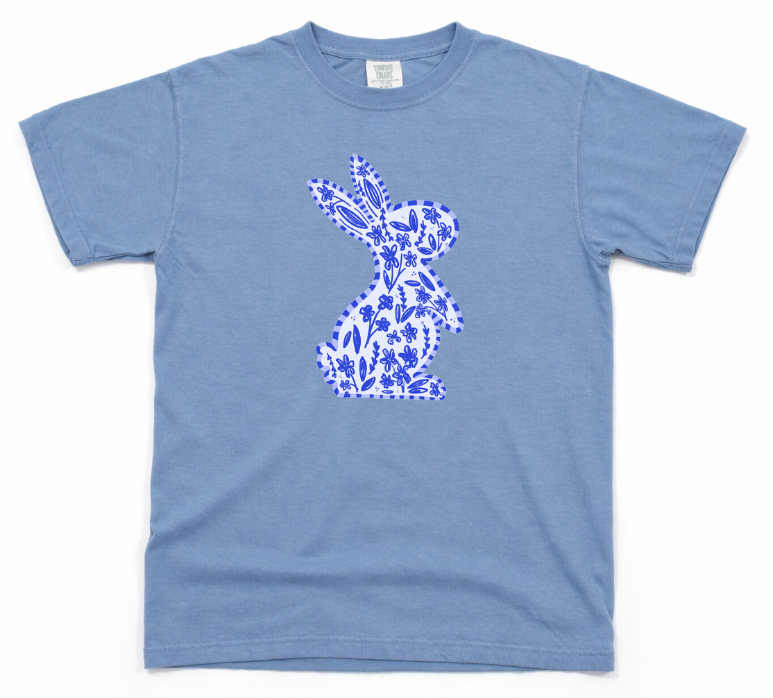 Blue t-shirt with a white floral bunny design on a white background