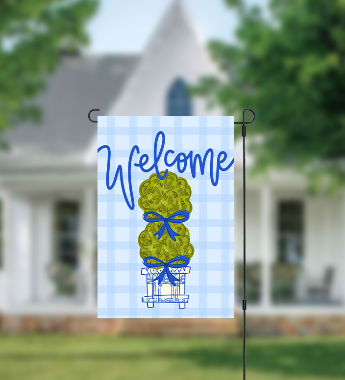 Garden flag with 'Welcome' text and topiary design in front of a house