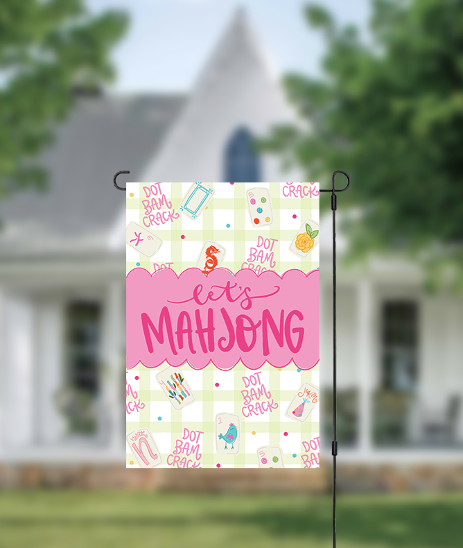 Decorative garden flag with 'Let's Mahjong' text in front of a house.