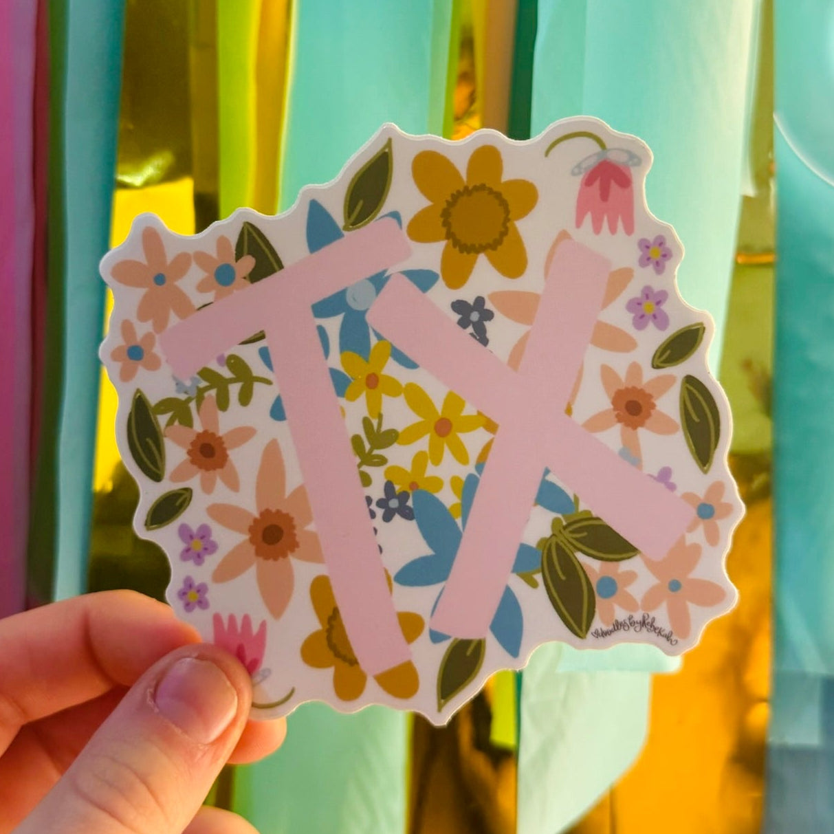 Doodles by Rebekah Texas "TX" state pride floral sticker. This whimsical hand-painted vinyl decal with botanical accents and pink lettering is a perfect gift for Texans to decorate water bottles, laptops, and planners.