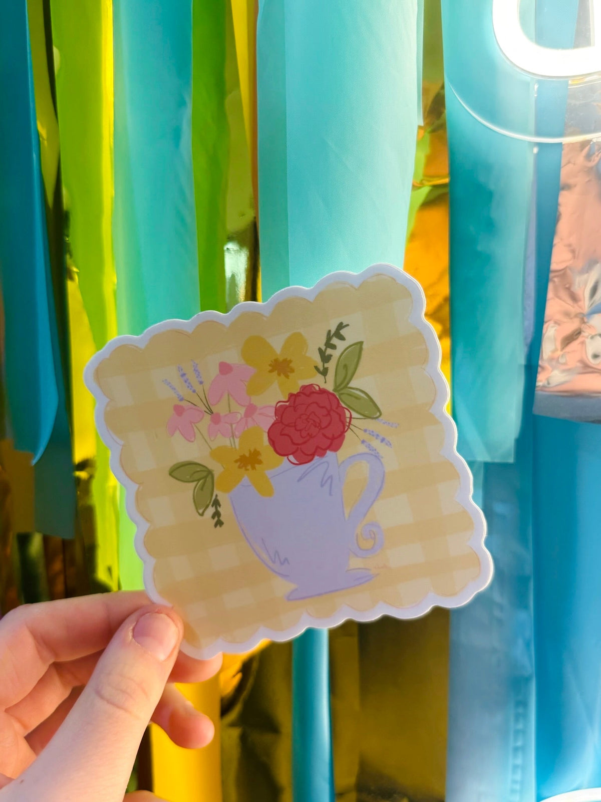 Doodles by Rebekah floral teacup sticker with scalloped edges. This whimsical vinyl decal features a hand-painted spring flower bouquet in a lavender tea cup, perfect for decorating laptops, water bottles, or journals.