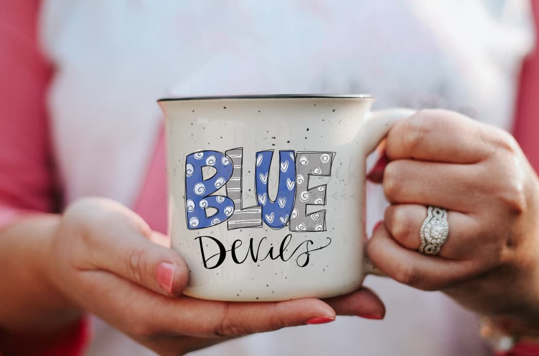 A hand holding a gray ceramic mug with a blue and white speckled pattern and the text 'Blue Devils' printed on it.
