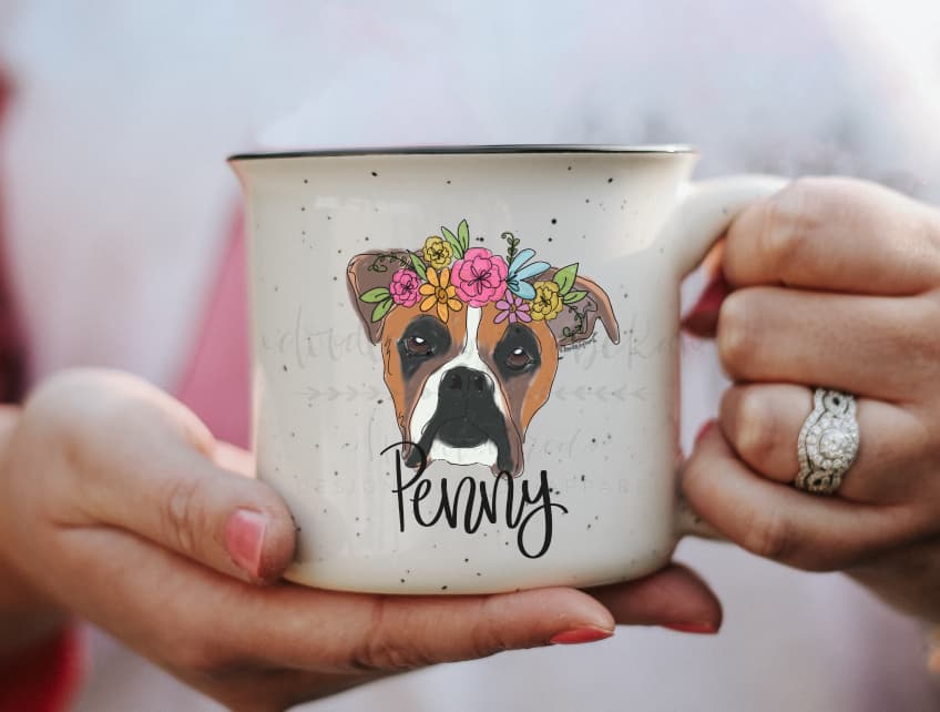 a speckled coffee mug with a whimsical drawing of a boxer dog with a flower crown with the dog's name at the bottom
