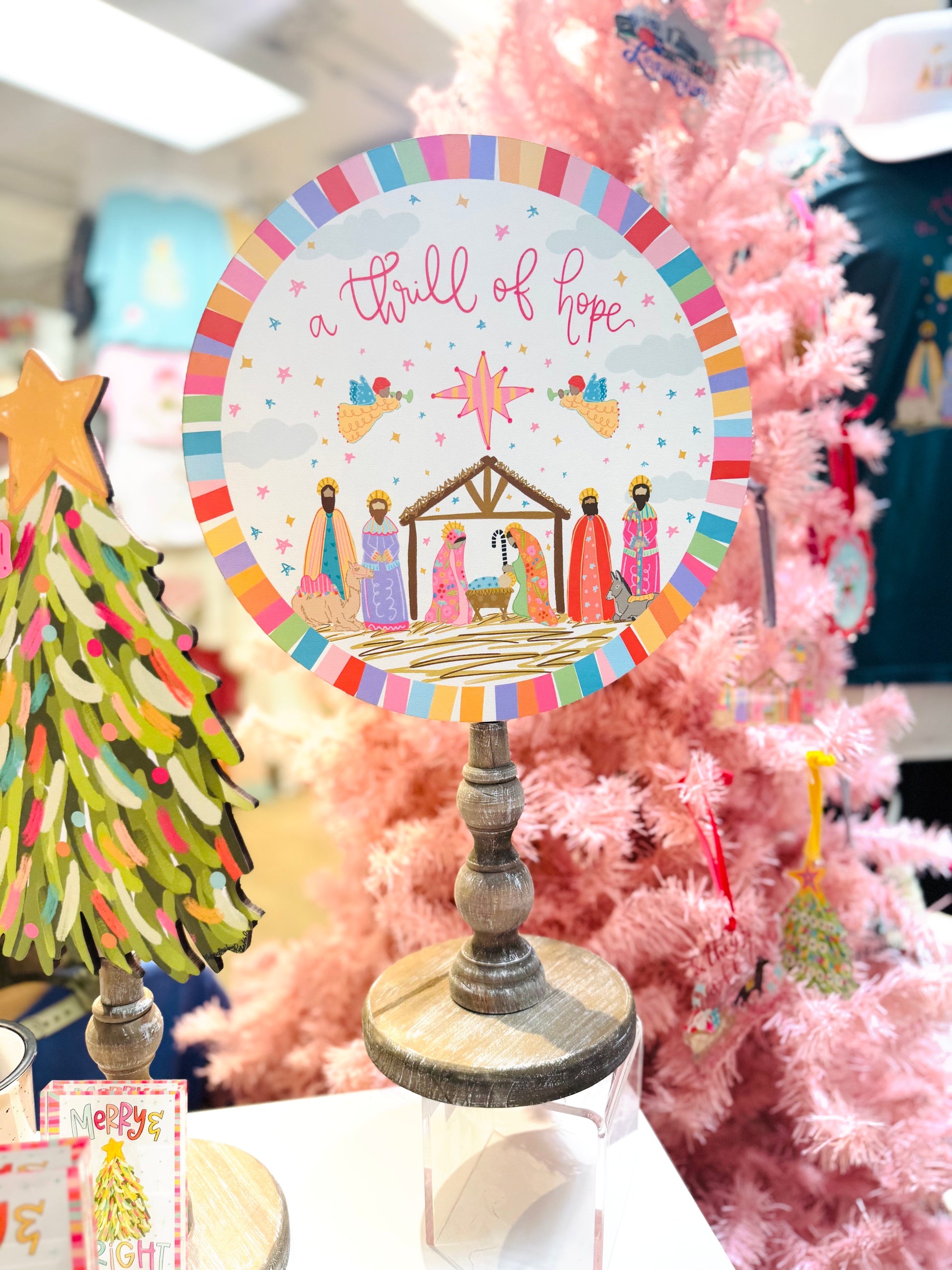 Decorative Christmas sign with nativity scene and 'a thrill of hope' text, surrounded by festive decorations.