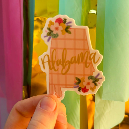 Doodles by Rebekah Alabama state pride sticker. This whimsical hand-painted vinyl decal with a pink checkered pattern and floral accents is a perfect gift for Alabamians to decorate water bottles, laptops, and planners.