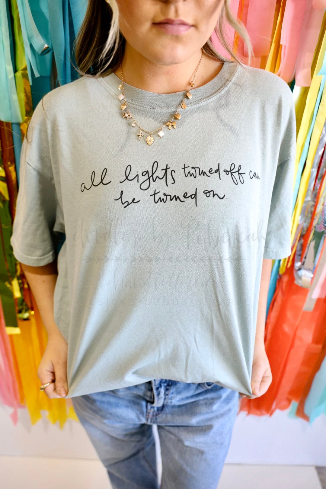 A woman wearing a light grey hand letter tshirt