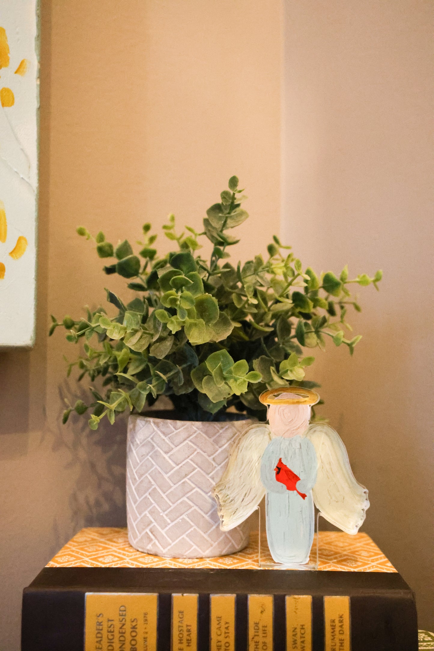 Potted plant on a table with an angel shelf sitter on a table 