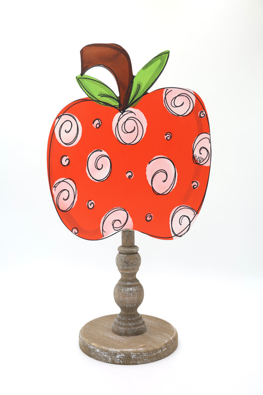 Decorative apple-shaped object with spiral patterns on a white background