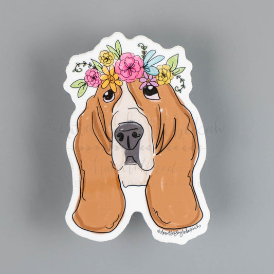 A sticker depicting a Basset Hound dog with a floral crown design.