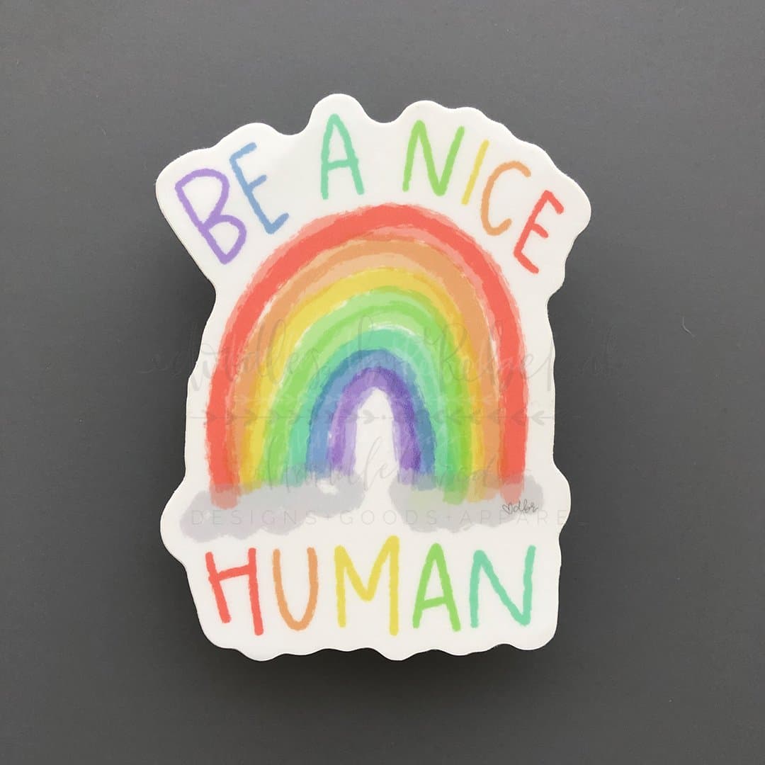 A sticker with a rainbow and the text 'BE A NICE HUMAN' in colorful, uppercase letters.