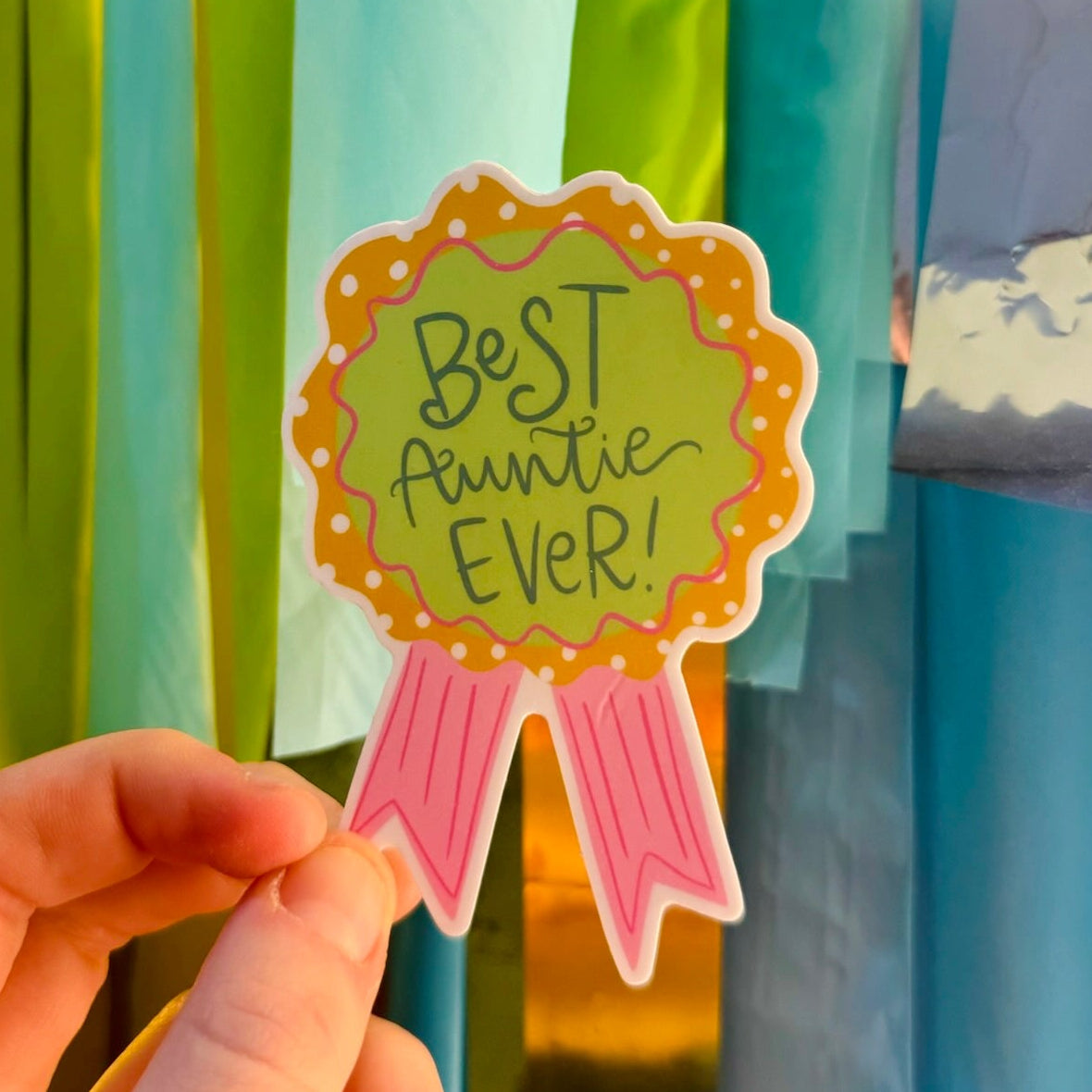 Doodles by Rebekah "Best Auntie Ever!" award ribbon sticker. This whimsical hand-painted vinyl decal is a perfect gift for aunts, ideal for decorating water bottles, laptops, or greeting cards to celebrate a special family member.