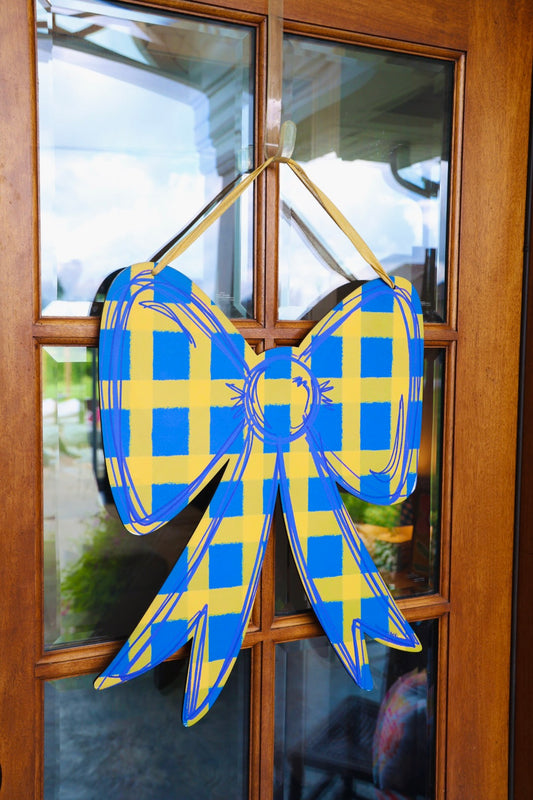 Blue and yellow checkered bow decoration on a glass door