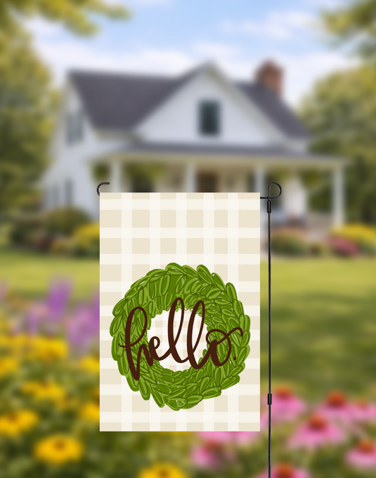 Decorative garden flag with 'hello' wreath design in front of a house and garden.