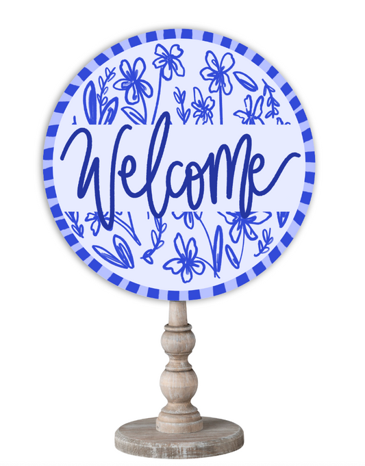 Doodles by Rebekah blue and white chinoiserie home decor with hand-lettered "Welcome" text on a rustic wooden stand.