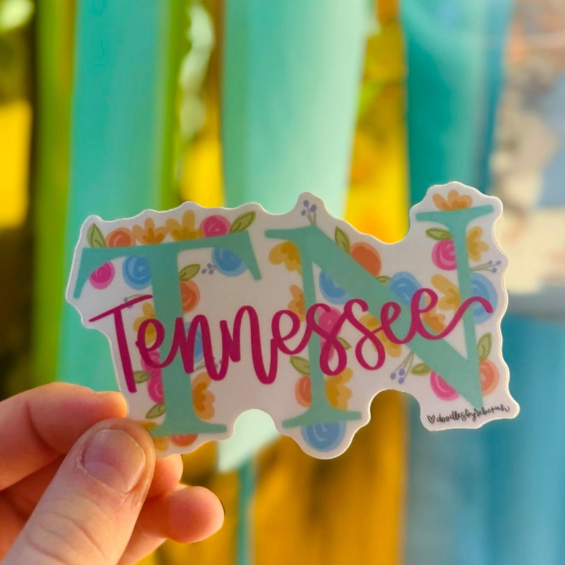 Doodles by Rebekah Tennessee state pride floral sticker. This whimsical hand-painted vinyl decal with botanical accents and pink cursive lettering is a perfect gift for Tennesseans to decorate water bottles, laptops, and planners.