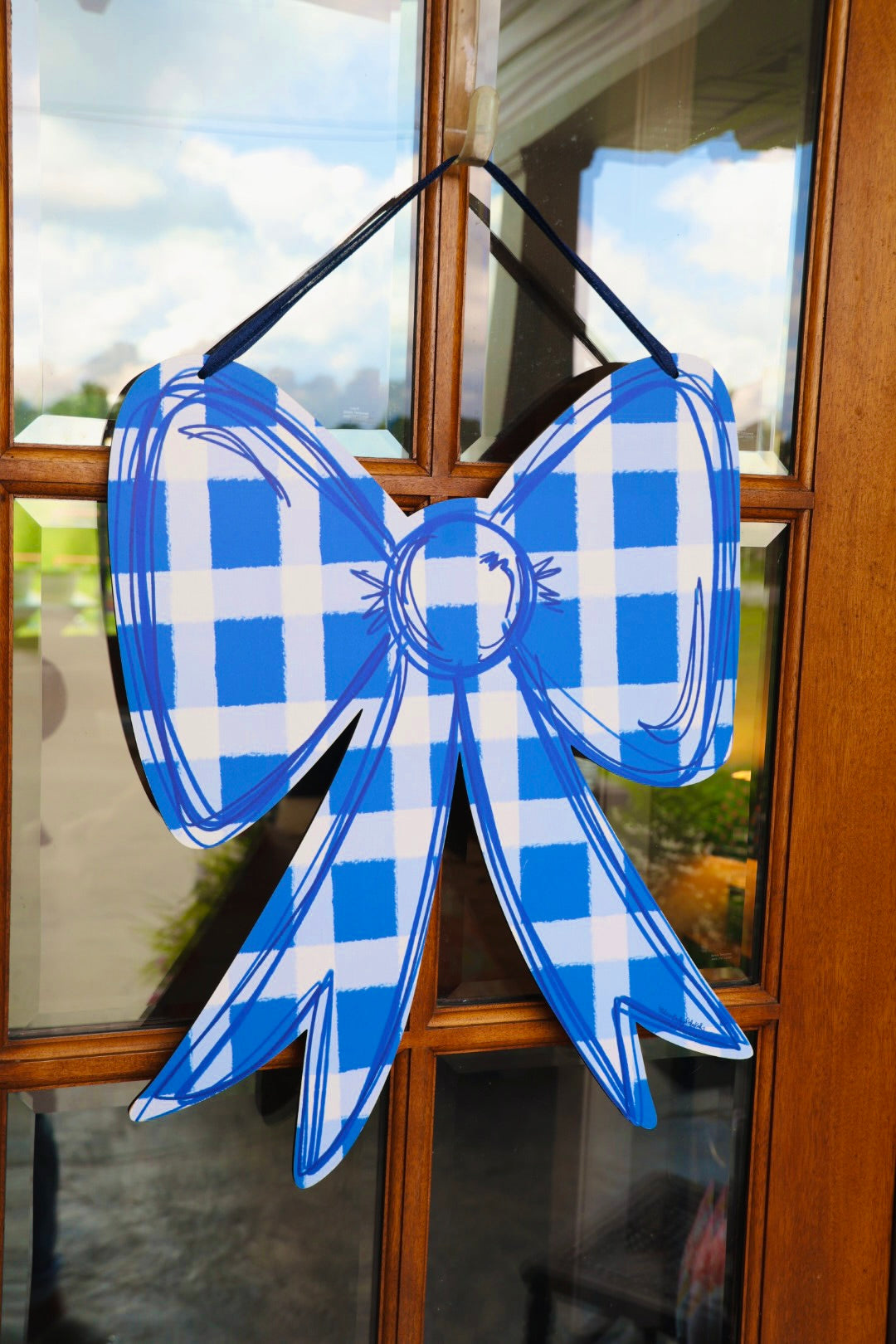 Blue and white checkered bow decoration on a glass door