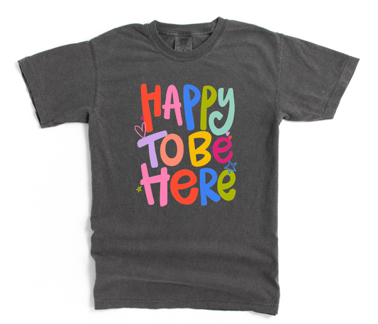 Gray t-shirt with colorful 'Happy To Be Here' text on a white background
