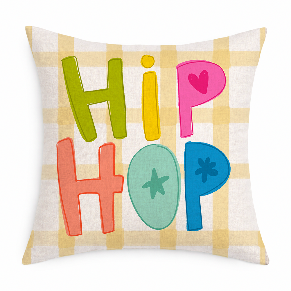 Decorative pillow with colorful letters spelling 'HIP HOP' on a plaid background