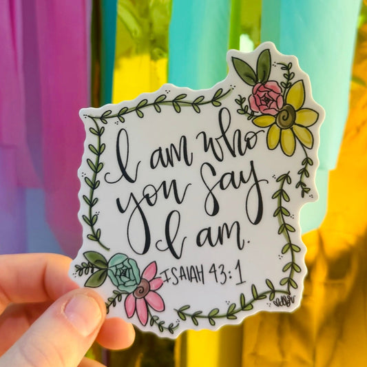 Doodles by Rebekah "I am who you say I am" Isaiah 43:1 inspirational Christian sticker. This whimsical hand-painted vinyl decal with botanical floral accents is a perfect faith-based gift for decorating Bibles, prayer journals, and water bottles.