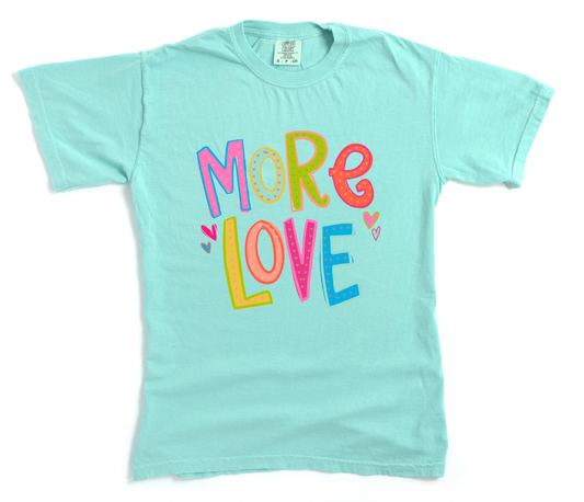 Light blue t-shirt with 'More Love' text in colorful letters on a white background