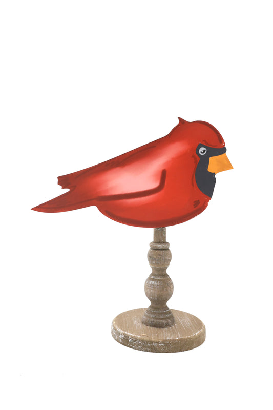 Red cardinal bird figurine on a wooden stand against a white background