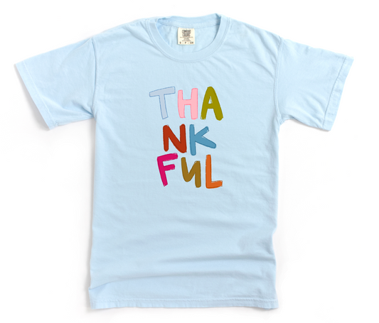 Light blue shirt with 'Thankful' in colorful text on a white background