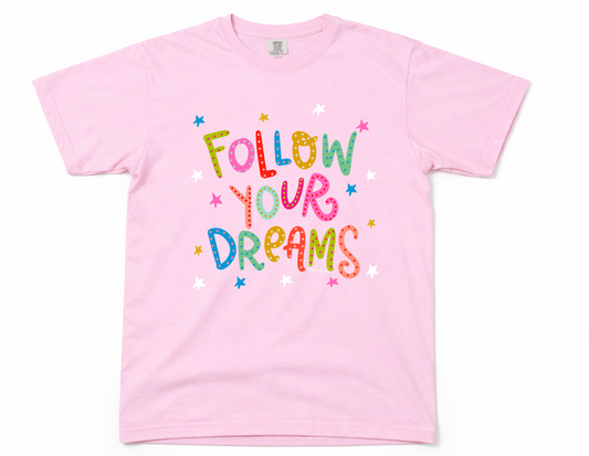 Pink t-shirt with 'Follow Your Dreams' text on a white background