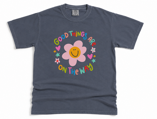 Gray t-shirt with a colorful flower and 'good things are on the way' text design on a white background