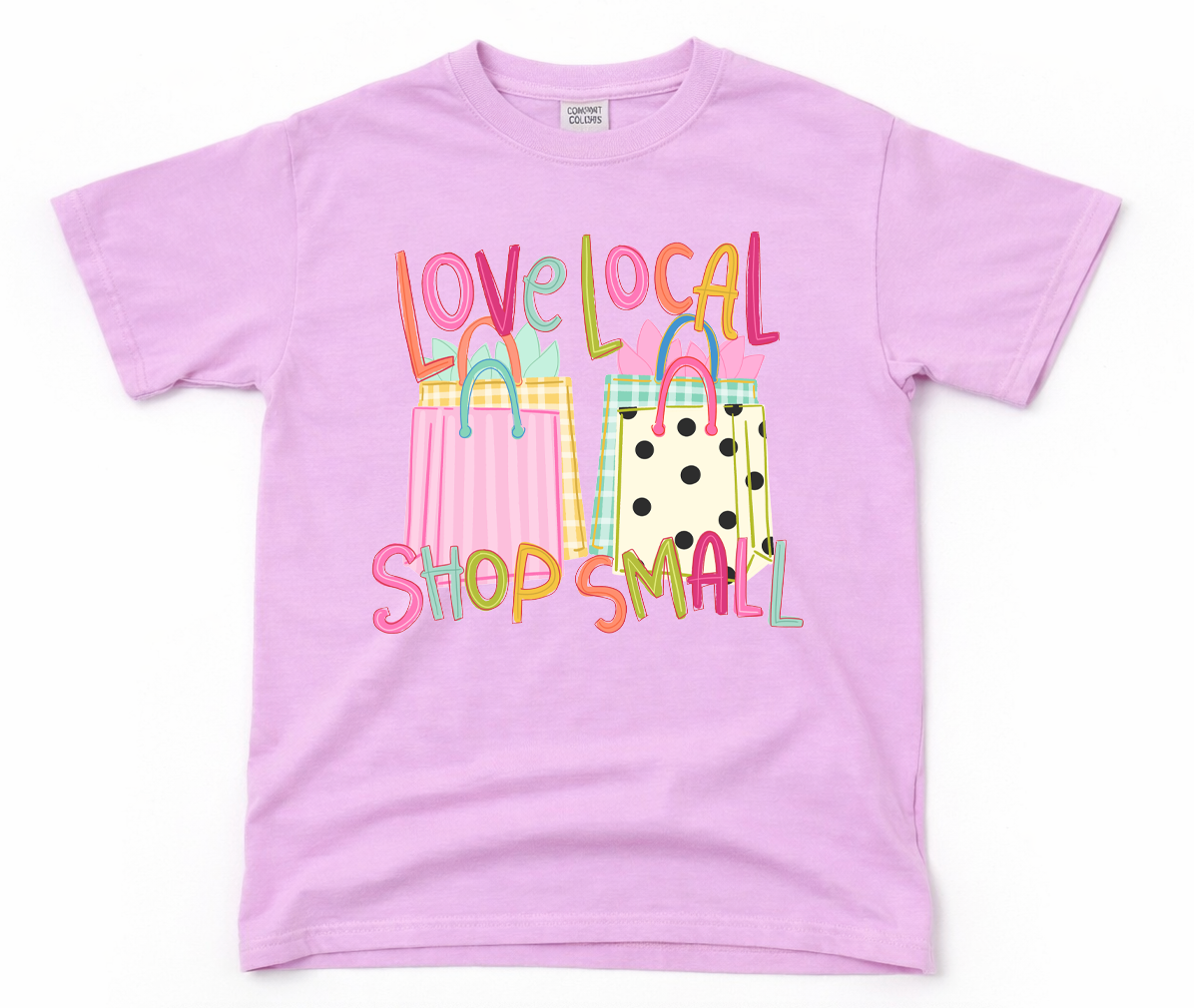Pink t-shirt with colorful shopping bag graphics and 'love local shop small' text on a white background