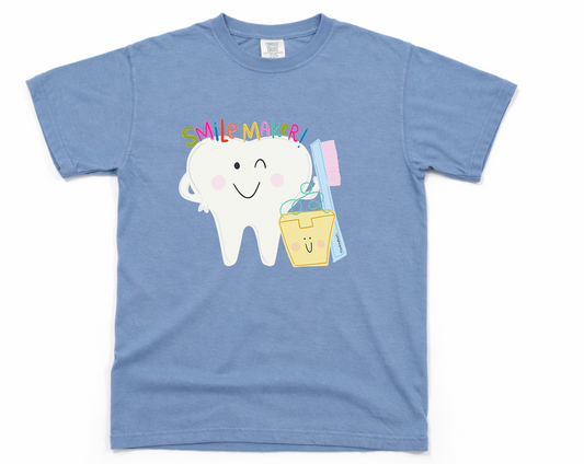 Blue t-shirt with a cartoon tooth and 'Smile Maker!' text on a white background