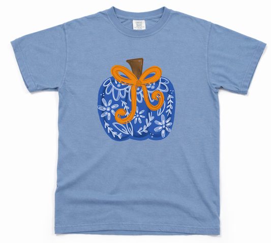 Blue t-shirt with a decorative pumpkin design featuring a bow on a white background