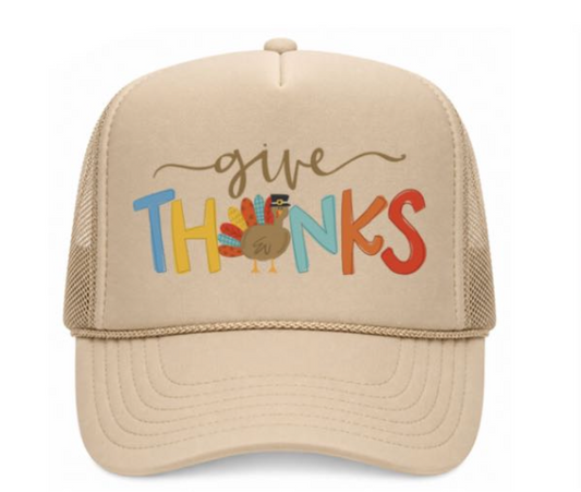 Beige trucker hat with 'give thanks' text and turkey graphic on a white background