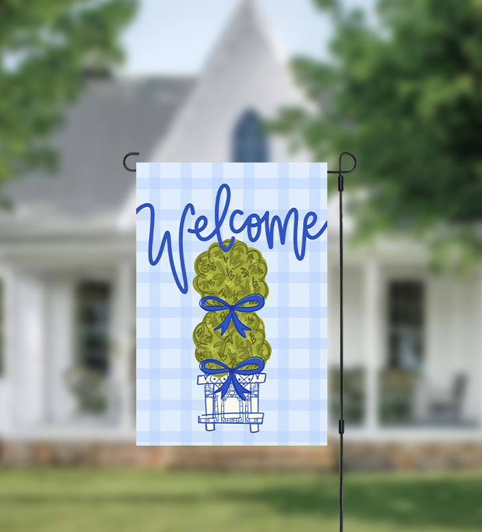 Garden flag with 'Welcome' text and topiary design in front of a house