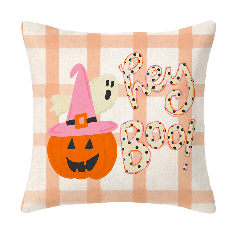 Decorative pillow with Halloween-themed design featuring a pumpkin, witch hat, ghost, and 'Hey Boo!' text on a checkered background.