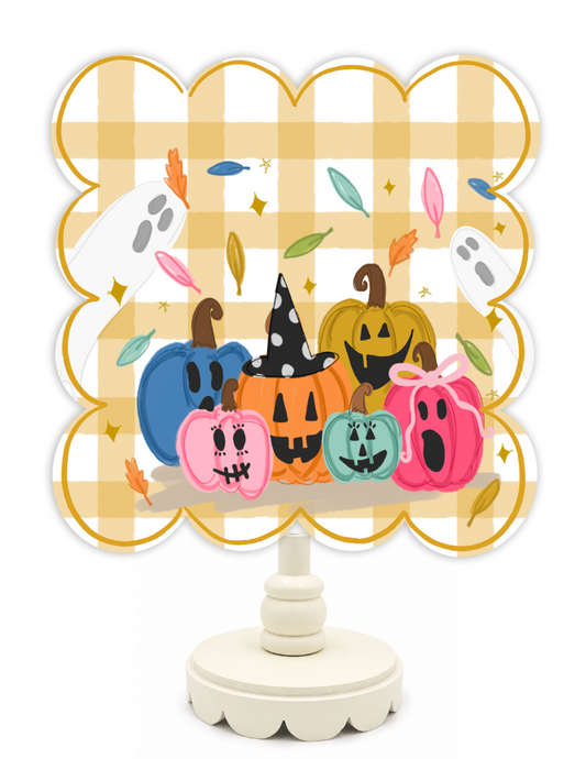 Decorative stand with colorful pumpkins and ghosts on a plaid background