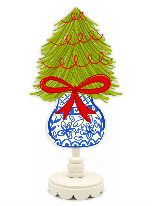 Decorative Christmas tree with a blue and white patterned base and red ribbon on a white background
