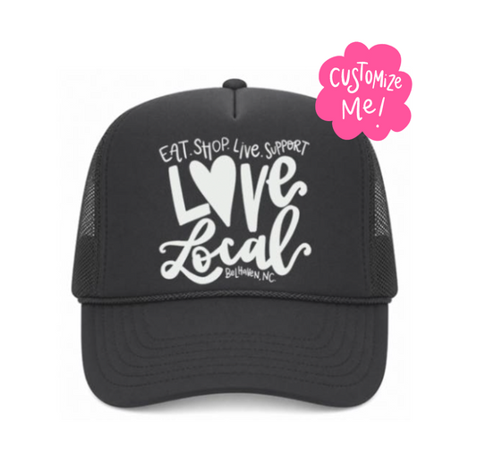 Black trucker cap with 'Love Local' text and a pink customization badge on a white background