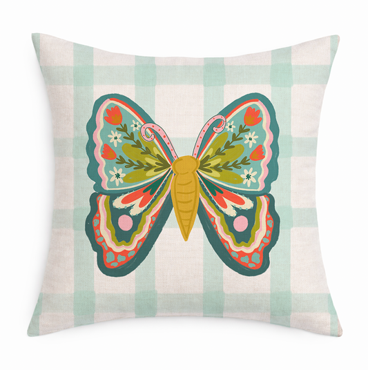 Decorative pillow with a colorful butterfly design on a plaid background