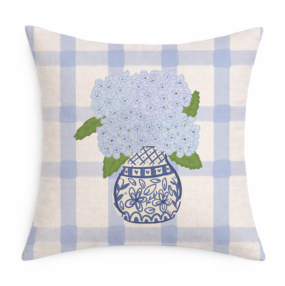 Decorative pillow with blue hydrangeas in a vase on a checkered background