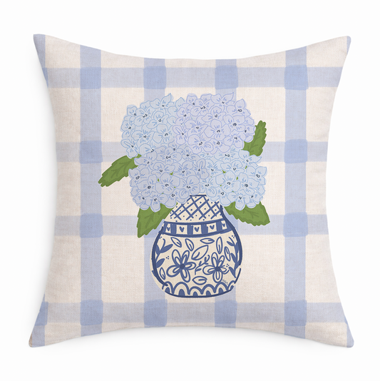 Decorative pillow with blue hydrangeas in a vase on a checkered background