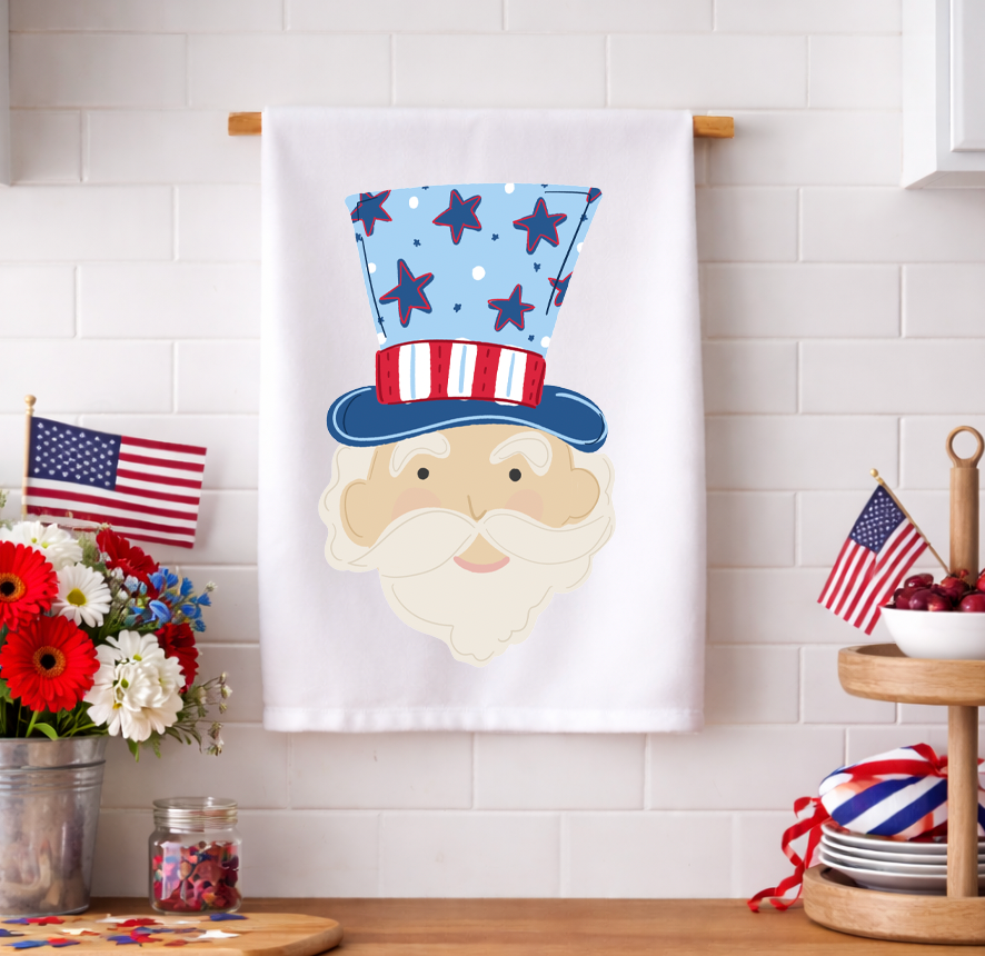 Patriotic Uncle Sam kitchen tea towel with American flag-themed top hat displayed in a red, white, and blue decorated kitchen setting.