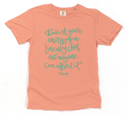 Pink t-shirt with teal text on a white background