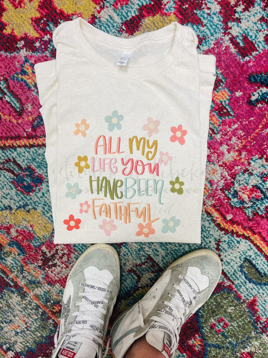 Shirt folded on the floor with the text "All my life you have been faithful" on it in handwritten font