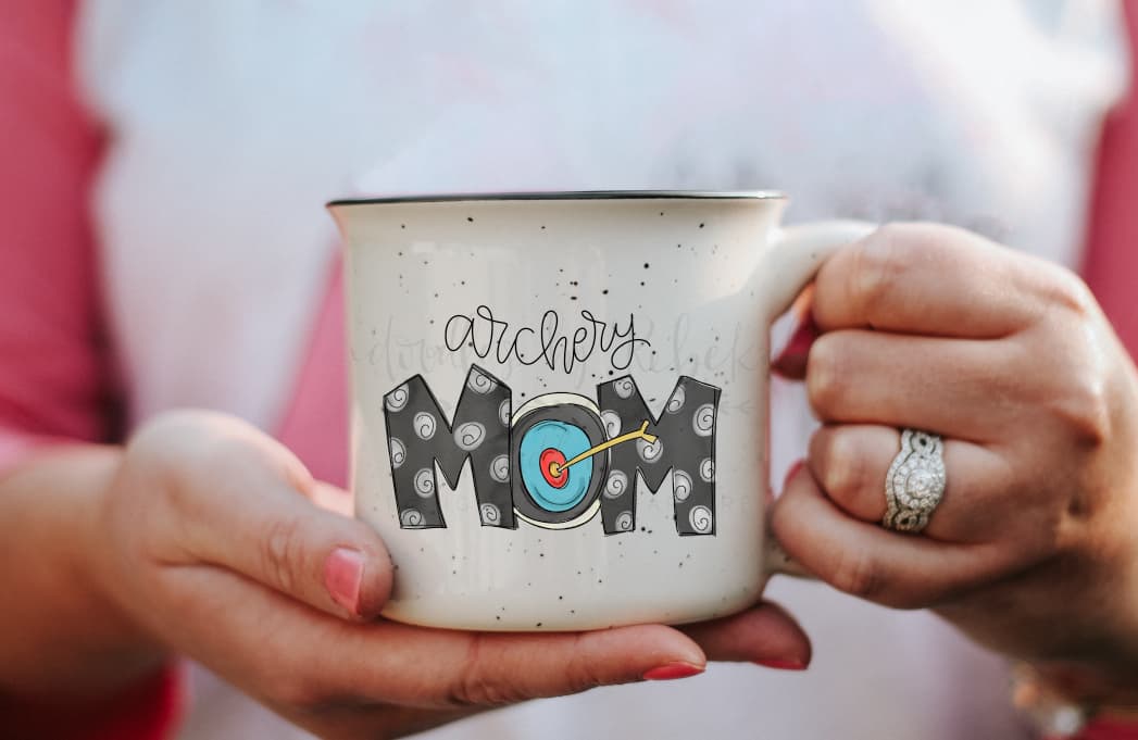 Close up of a person holding a coffee mug with archery mom design