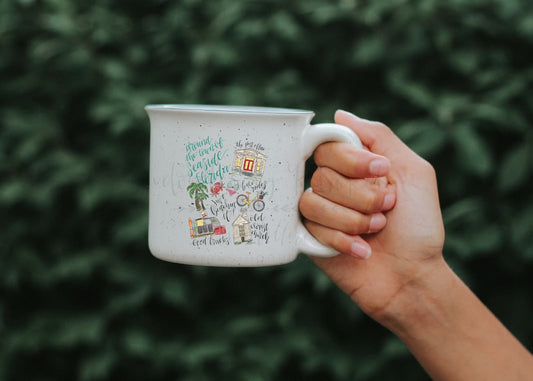 Close up of a white coffee mug with items describing Florida seaside